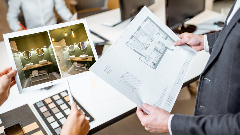 Designers discussing a bathroom design with a photo and a blueprint