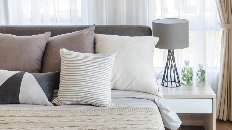 pile of throw pillows on top of tidy bed