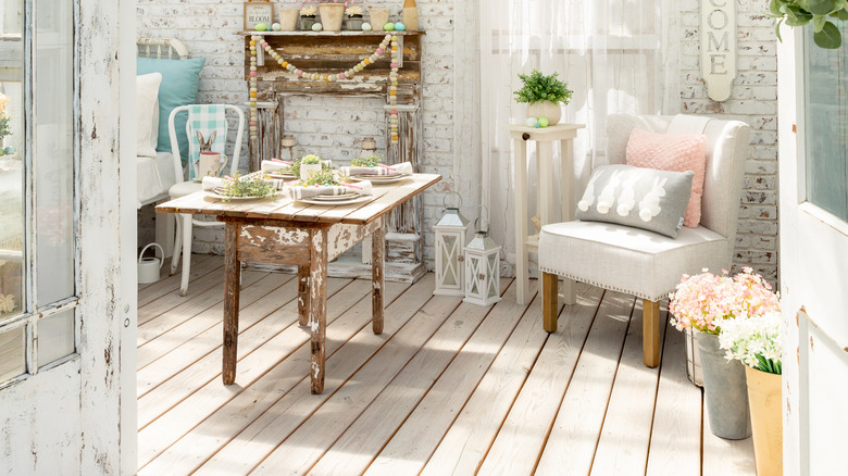 Distressed wooden table and faux mantel in a white-themed room