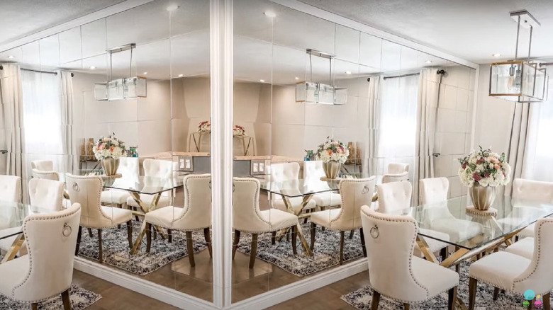 A large mirrored wall in the background of a dining room.