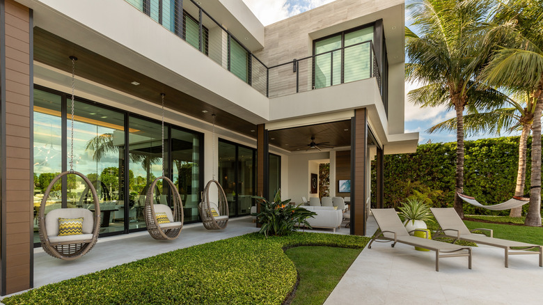 A minimalist landscape with neutral furnishings in front of a modern home