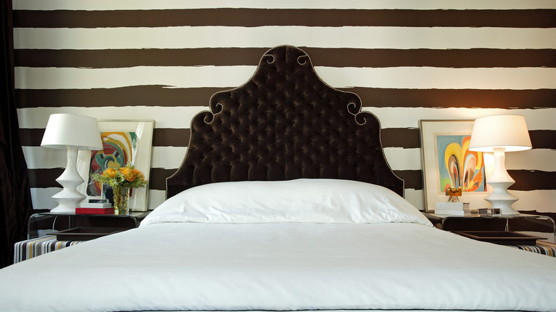 A bedroom with a black and white striped wall.