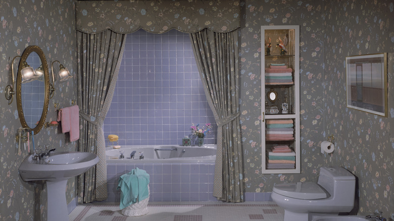 A lavender '80s bathroom with floral wallpaper.