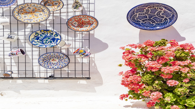 Colorful patterned plates hanging on white exterior wall