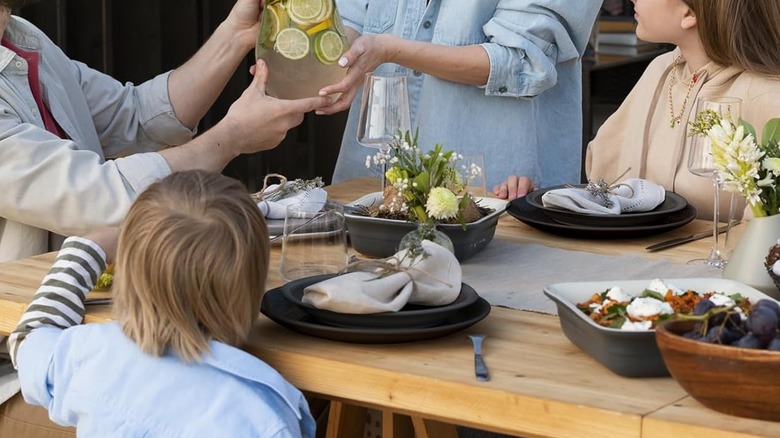 A family dining outdoors with Quatish's Unbreakable 24-piece Plate and Bowl Set
