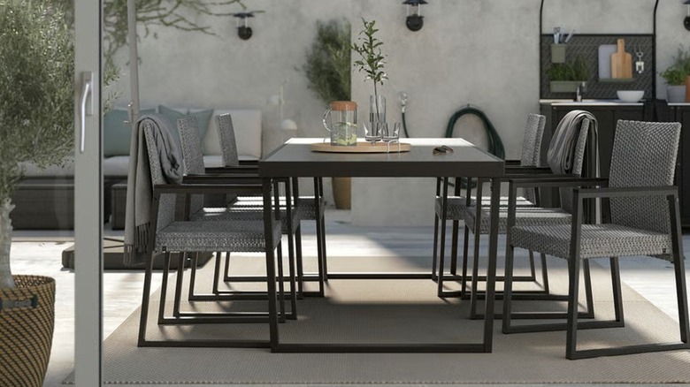 A black table with refreshments on top and chairs around it