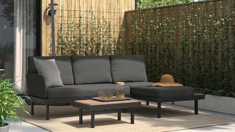 A black three seater sofa on a patio
