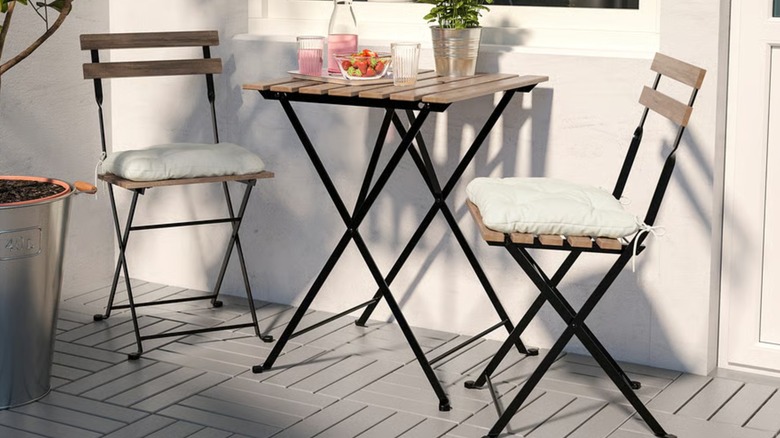 Table holding fruits and drinks with two chairs around it