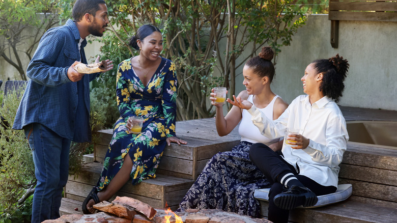 Friends drinking near a fire pit on a patio
