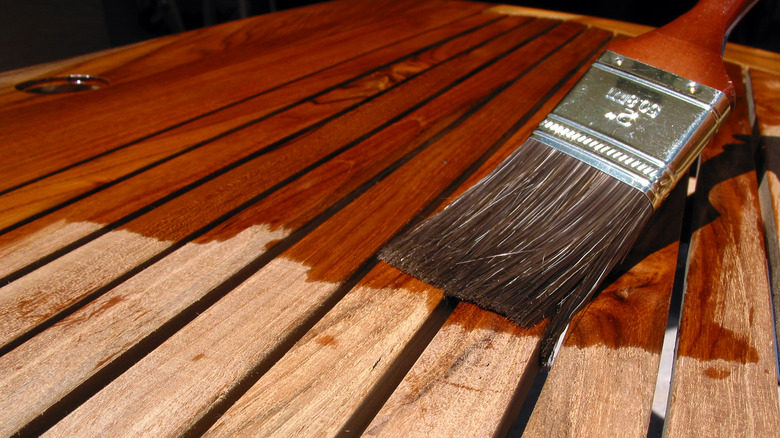 Paintbrush applying wood varnish