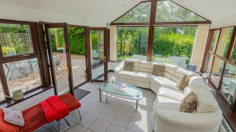 A sunroom with white sofa