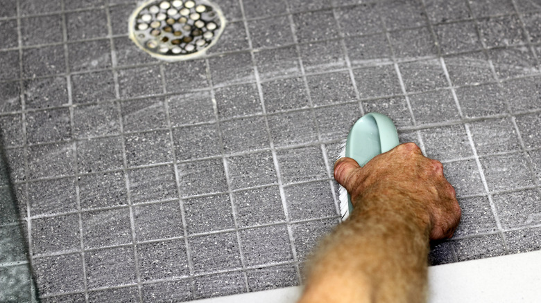 Man scrubbing grout lines