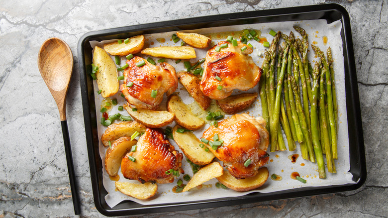 Close up of baking sheet holding cooked chicken and vegetables
