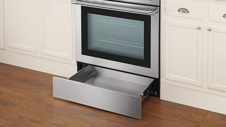 Close up of empty oven with bottom storage drawer open