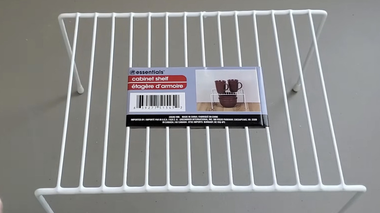 White wire cabinet shelves being picked up off the shelf at Dollar Tree