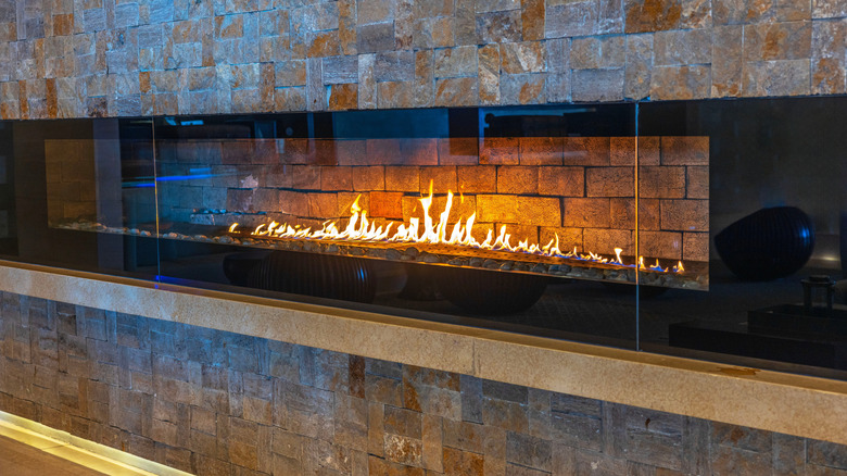 A linear fireplace surrounded by bricks