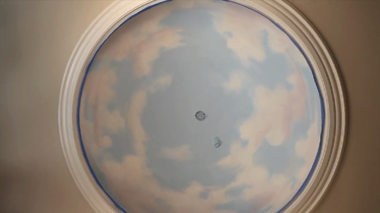 An overhead circular mural of clouds.