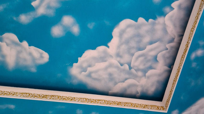 A close up of a painted cloud in an ornate frame.