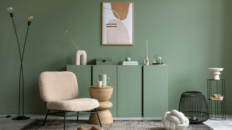 A living area with a sagey green wall color