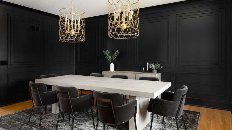 A dining room with black painted walls and a large table