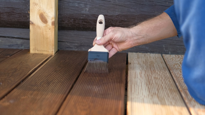 person painting wood flooor
