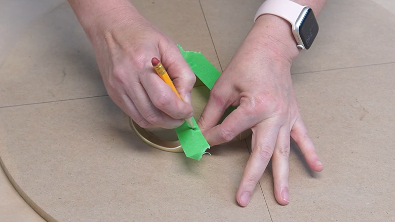 Marking the location of hardware bolt holes on green painter's tape