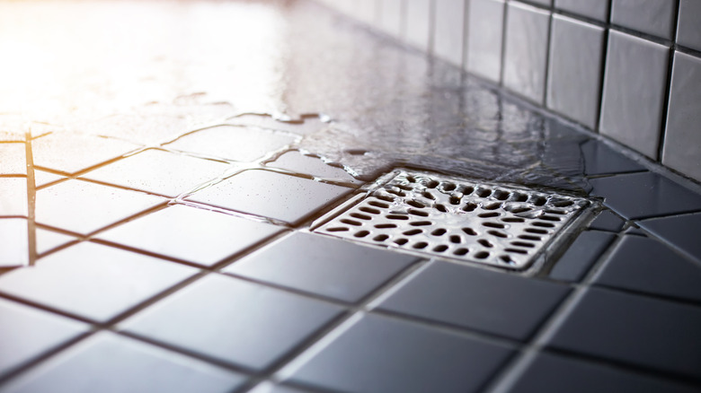 Water flowing in tiled floor in modern bathroom