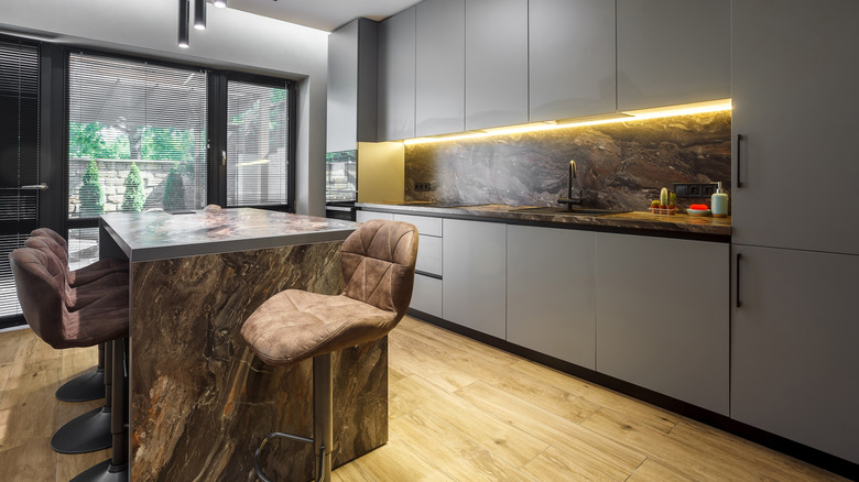 A panel ready refrigerator is featured in a sleek gray kitchen