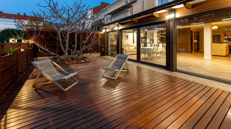 A garden scene at night showing a large, single-level deck.