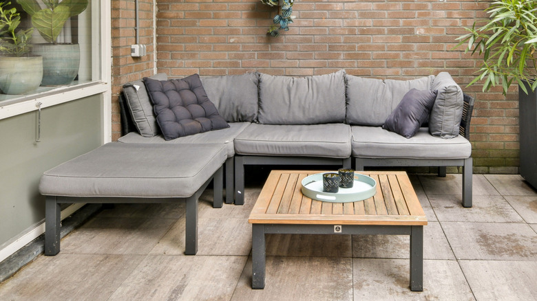 An urban patio with a grey outdoor sofa suite.