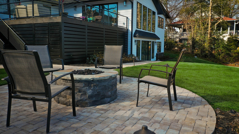 A residential patio with a stone-built hardscape fire pit.