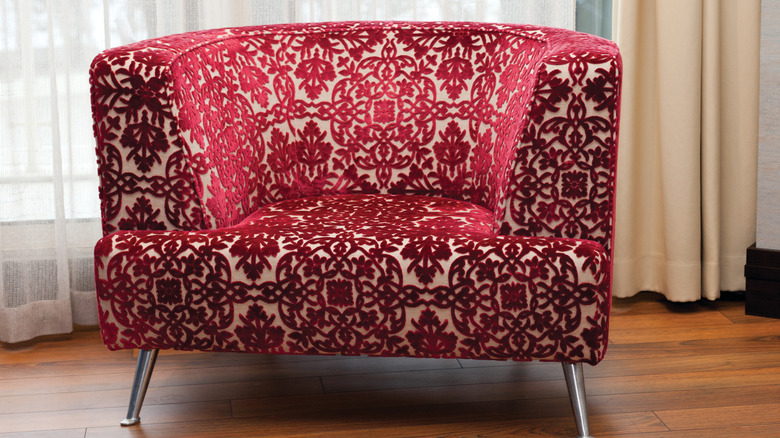 A patterned red velvet arm chair.