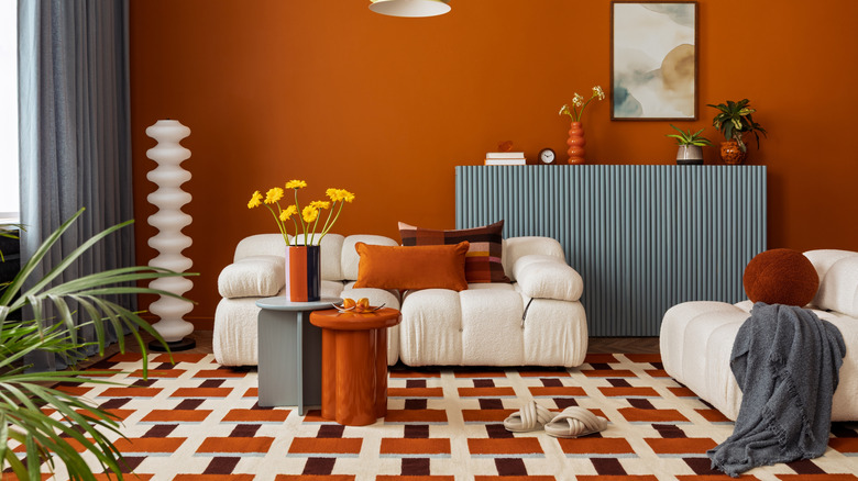 A living room dominated by a bold, patterned carpet in shades of rust, brown, and white