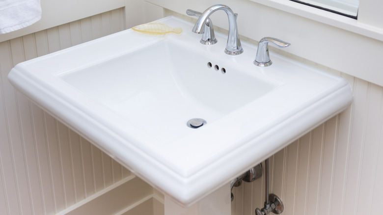 A simple white pedestal sink.
