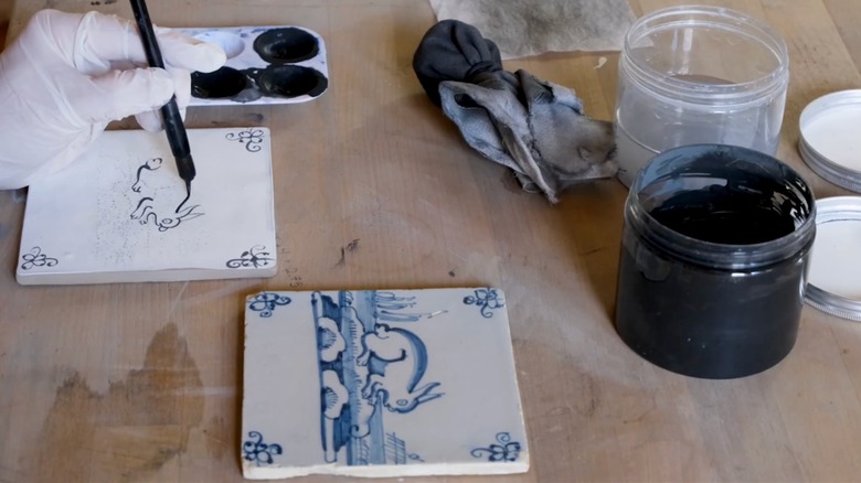 artist painting delft tile
