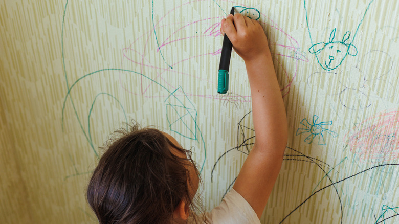 child drawing on wall