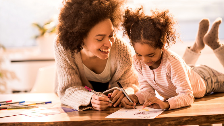 woman, child coloring with markers