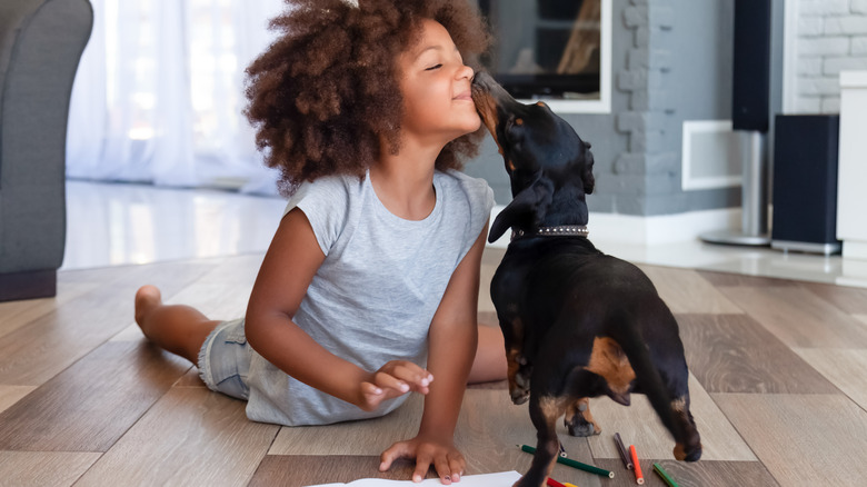 A girl and a dog on a floor