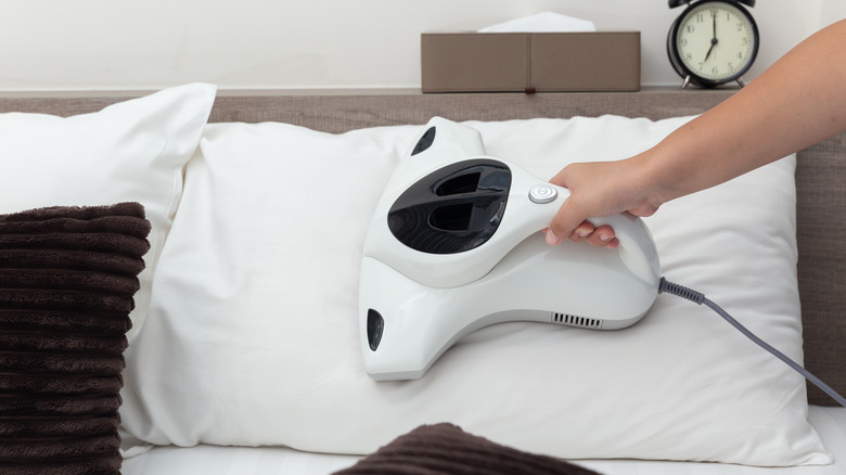 person vacuuming pillow