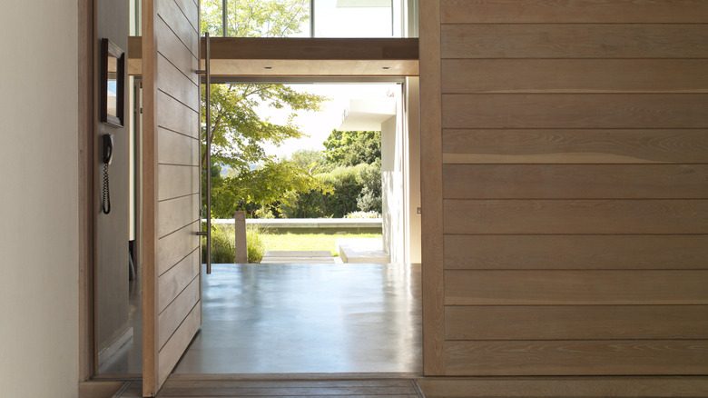 A large pivot door open in a home