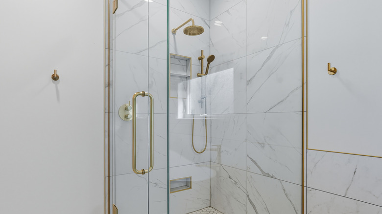 A glass hinged shower door in a modern bathroom