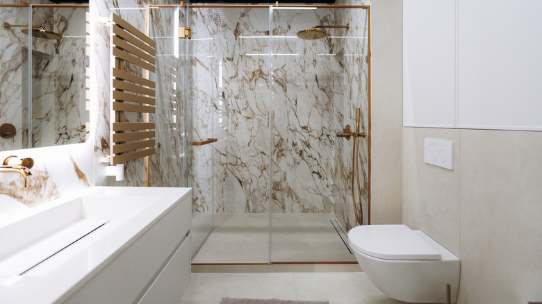 Shower with white and brass-color stone walls