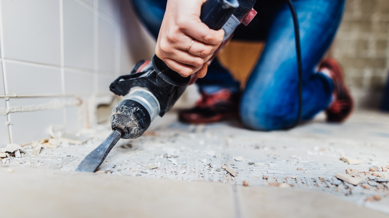 Woman renovating a bathroom and switching out the tiles