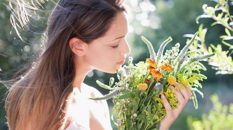 woman smelling bunch flowers