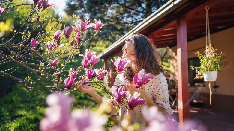 Woman enjoying blooms of magnolia