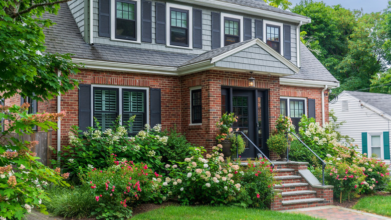 A home's front yard is covered in plants and flowers