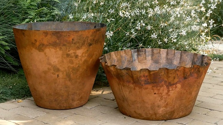 Copper planters sitting in an outdoor garden