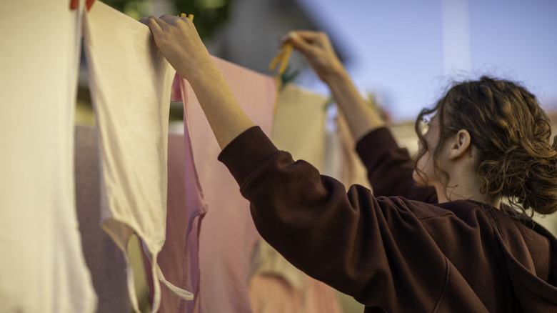 person using wooden clothespin on line