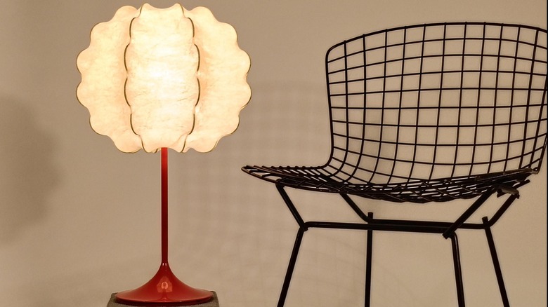Organic form "cocoon" lamp from the '60s sitting next to a black wire chair