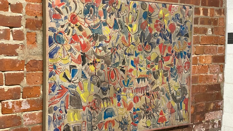 Abstract original art from the '60s hanging on a brick wall